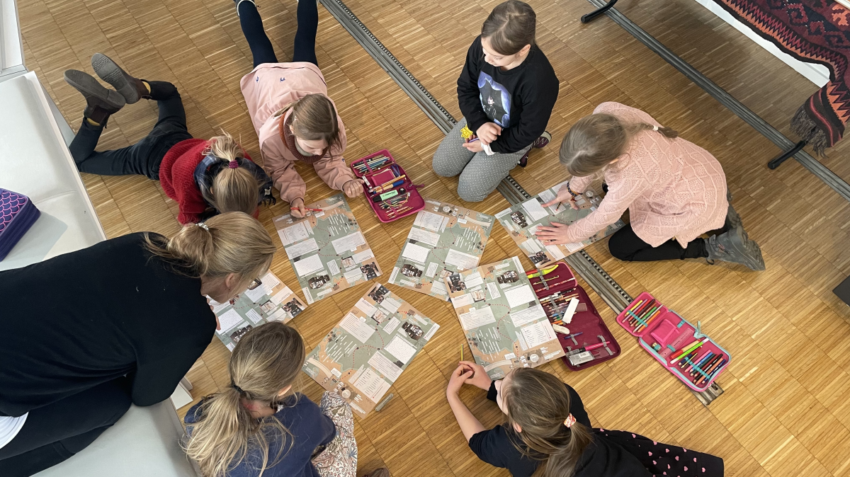 Eine Schulklasse erfreut sich an der Schatzkarte, die durchs Bibelzentrum führt.