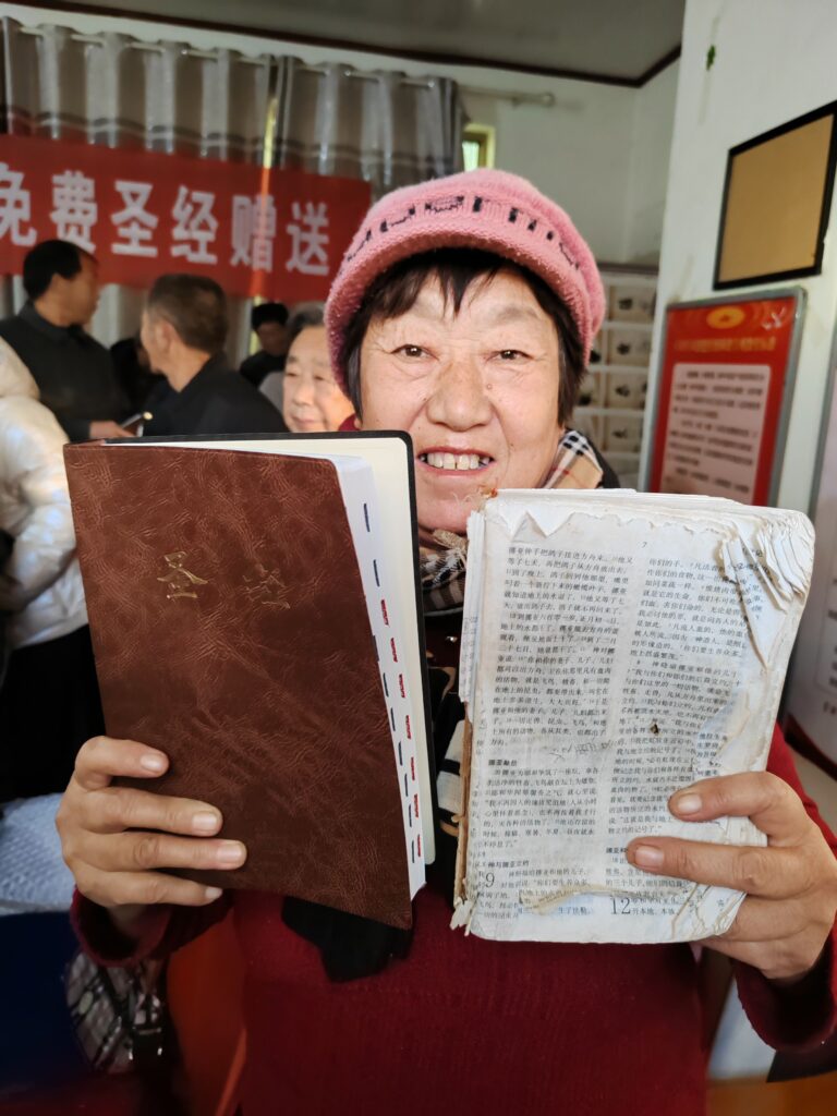 Xu Zhijun, 65, zeigt ihre neue
Großdruckbibel und die abgenutze
Bibel, die sie seit über 30 Jahren hat.