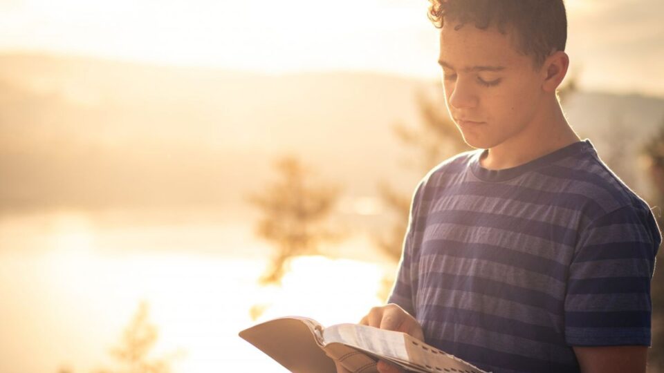 Junger Mann mit Bibel in der Hand
